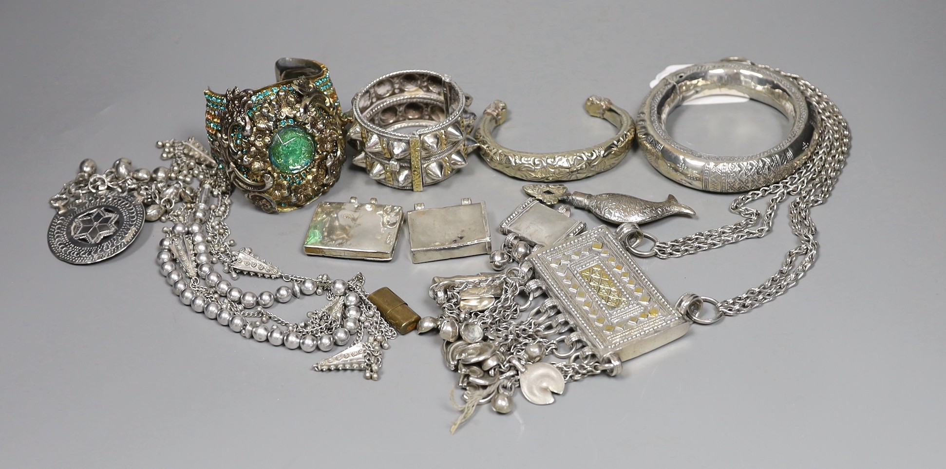 A small group of Middle Eastern mainly white metal jewellery, including bangles, bracelets and an Omani Hirz necklace.